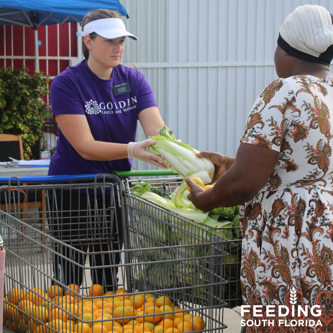 A dedicated volunteer graciously distributes an assortment of fresh, vibrant produce to a grateful recipient, fostering a meaningful connection through the act of giving.