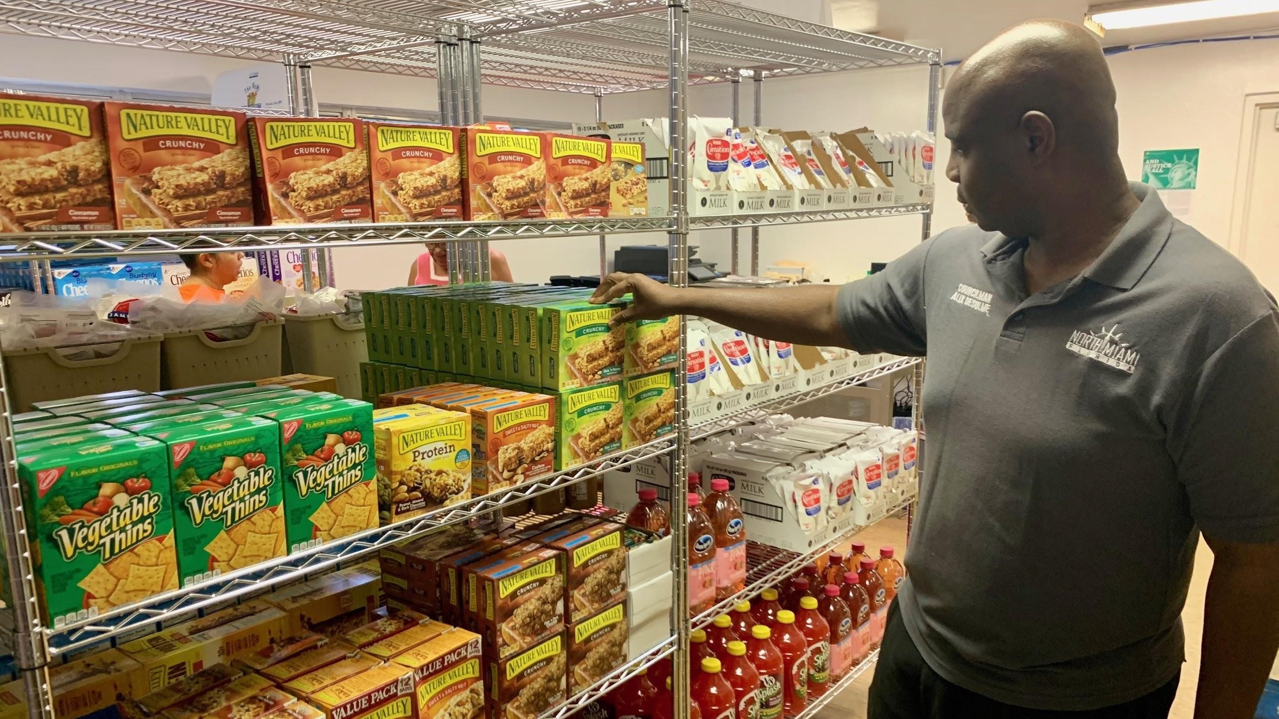 Councilman Alix Desulme checks out the products available at North Miami’s new municipal food pantry, NoMi Food Market. (Imogen Francis/South Florida Media Network)