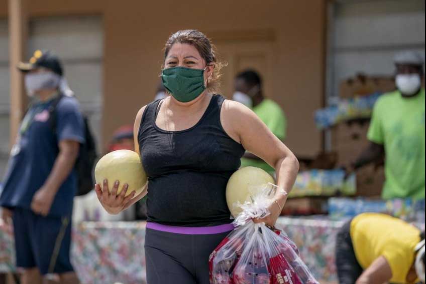 Woman Carries Food to Car at Food Distribution