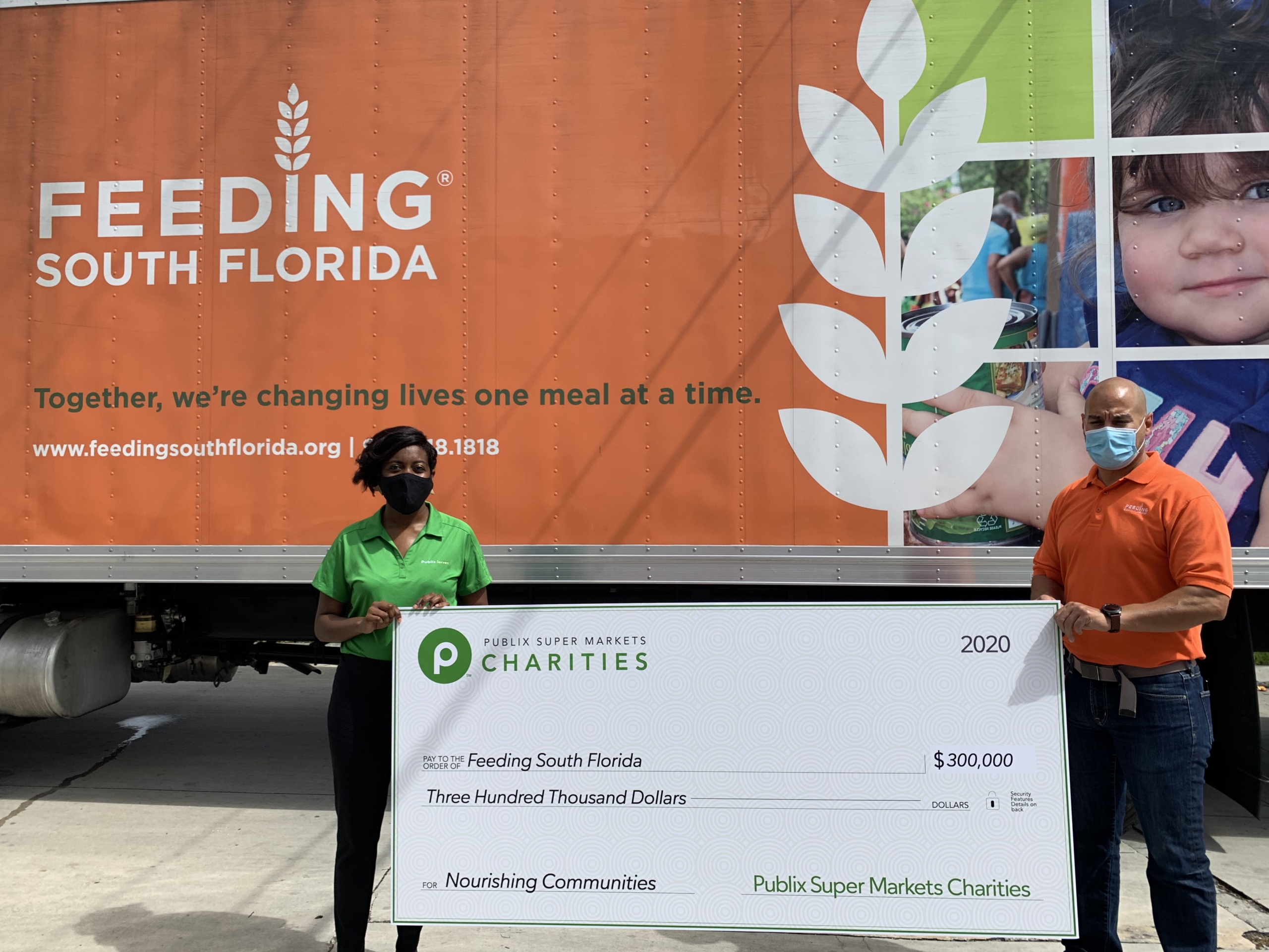 Publix's Robyn Hankerson and Feeding South Florida's Paco Velez hold a $300,000 check from Publix Charities.