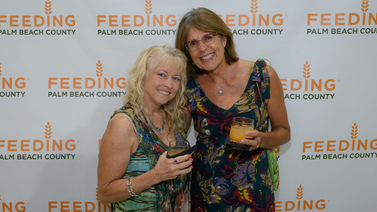 Image of two women posing with their drinks.