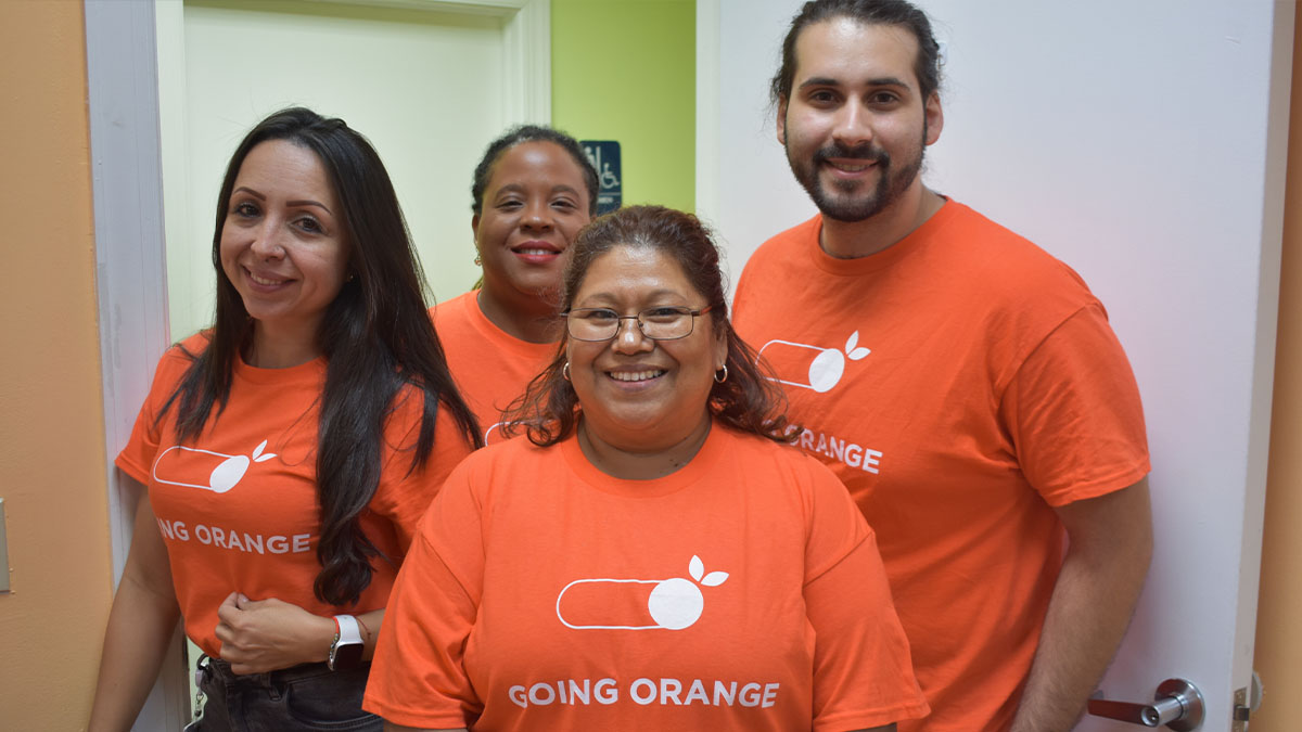 Group showing off orange Hunger Action Month t-shirts.